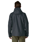 Back of man wearing the Patagonia men's torrentshell 3 layer rain jacket in smolder blue. Jacket has a relaxed fit