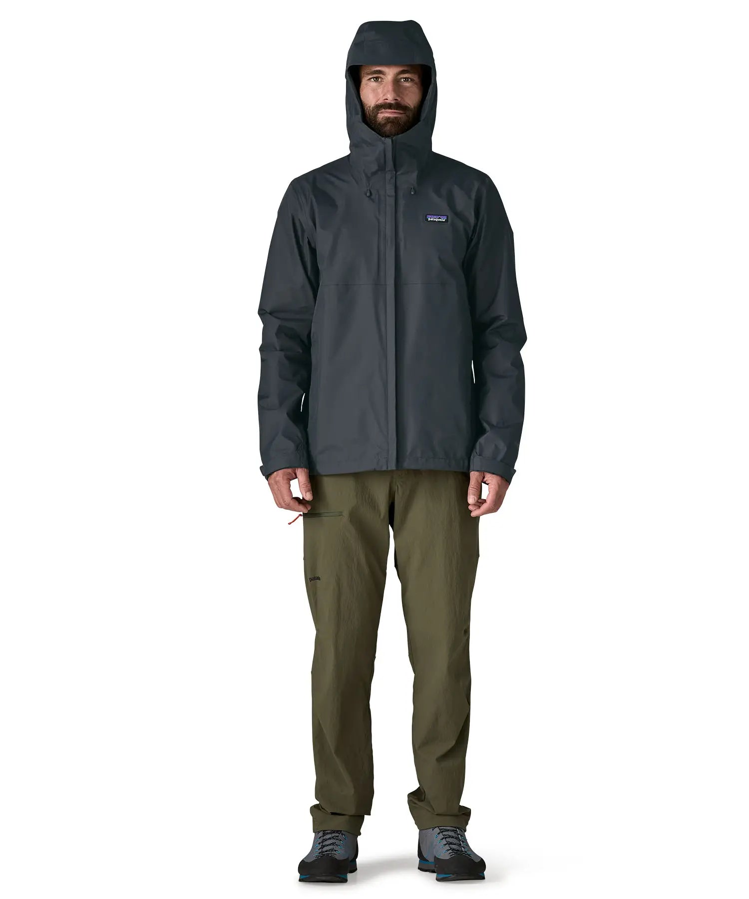 Man wearing the Patagonia men's torrentshell 3 layer rain jacket in smolder blue showing full front zip fastened and hood over the head
