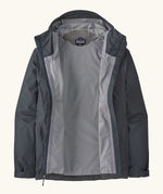 An open Patagonia men's torrentshell 3 layer waterproof rain jacket in smolder blue. showing microfibre fleece panel on the neck for warmth