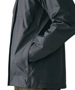 Side of man wearing the Patagonia men's torrentshell 3 layer rain jacket in smolder blue. Showing close up hand in the handwarmer pocket