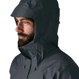 Man wearing the Patagonia men's torrentshell 3 layer rain jacket in smolder blue. Showing close up of adjustable hood over the head