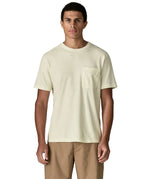 Man wearing Patagonia's men's trail harbour short sleeve tee in cream showing front pouch chest pocket