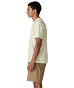 Side of man Man wearing Patagonia's men's trail harbour short sleeve tee in cream. T-shirt has a relaxed fit