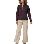 A person wearing the Patagonia Women's Wide Leg Cord Pants - Pumice, with a plum coloured Patagonia Fleece