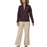 A person wearing the Patagonia Women's Wide Leg Cord Pants - Pumice, with a plum coloured Patagonia Fleece