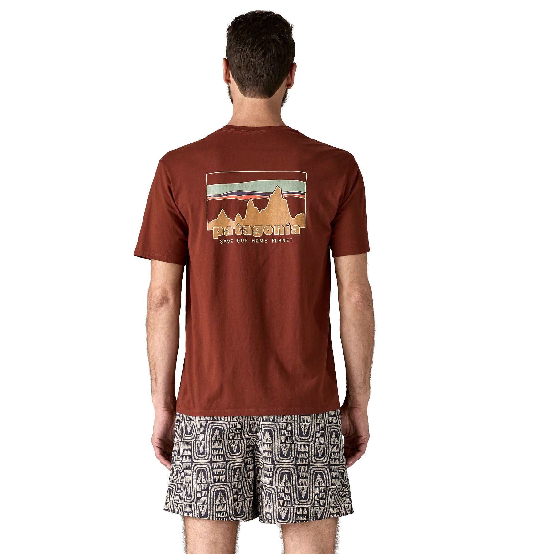 The back of a man wearing the Patagonia Men's 73 Skyline Organic T-Shirt. A brown top with short sleeves with a brand logo in a sketch design printed on the back available at Babipur