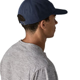 Man wearing Patagonia's p6 label trad cap in navy. Shows the adjustable strap on the back 