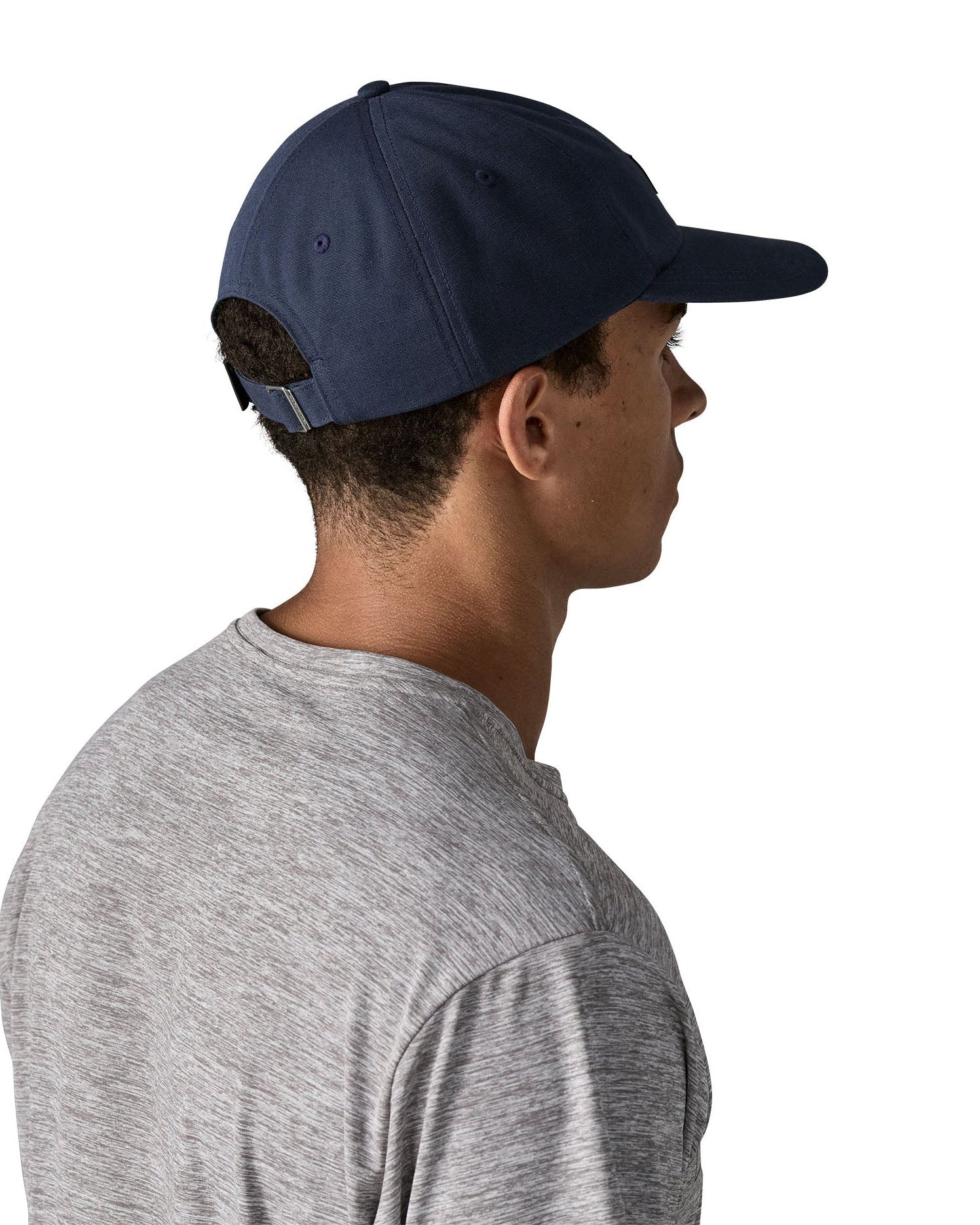 Man wearing Patagonia's p6 label trad cap in navy. Shows the adjustable strap on the back 