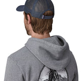 Man wearing Patagonia's p6 logo lopro trucker hat in navy, shows the breathable mesh back panel adjustable strap