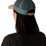 Woman wearing Patagonia's p6 logo lopro trucker hat in white, shows the light blue breathable mesh back panel adjustable strap