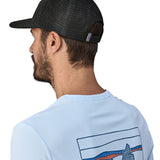Man wearing Patagonia's logo trucker hat in black shows the breathable mesh back panel and adjsutable strap