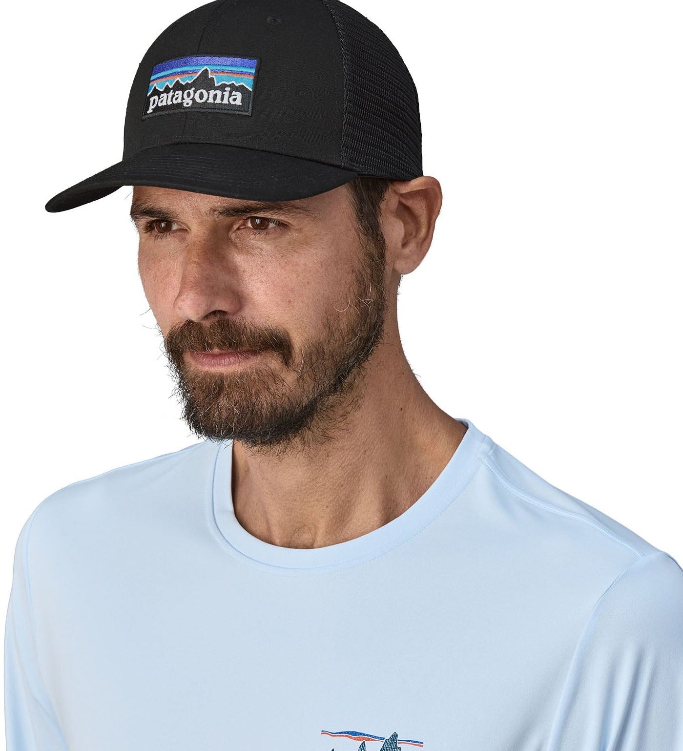 Man wearing Patagonia's logo trucker hat in black with a breathable mesh back panel