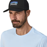 Man wearing Patagonia's logo trucker hat in black with a breathable mesh back panel