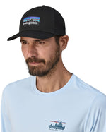Man wearing Patagonia's logo trucker hat in black with a breathable mesh back panel