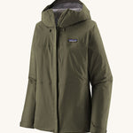 Patagonia Women's Torrentshell 3L Rain Jacket - Pine Needle Green zipped up the front, on a cream background.