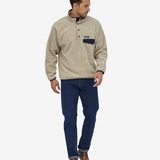 An adult wearing the Patagonia Men's Synchilla Snap-T Fleece - Oatmeal Heather, and blue jeans
