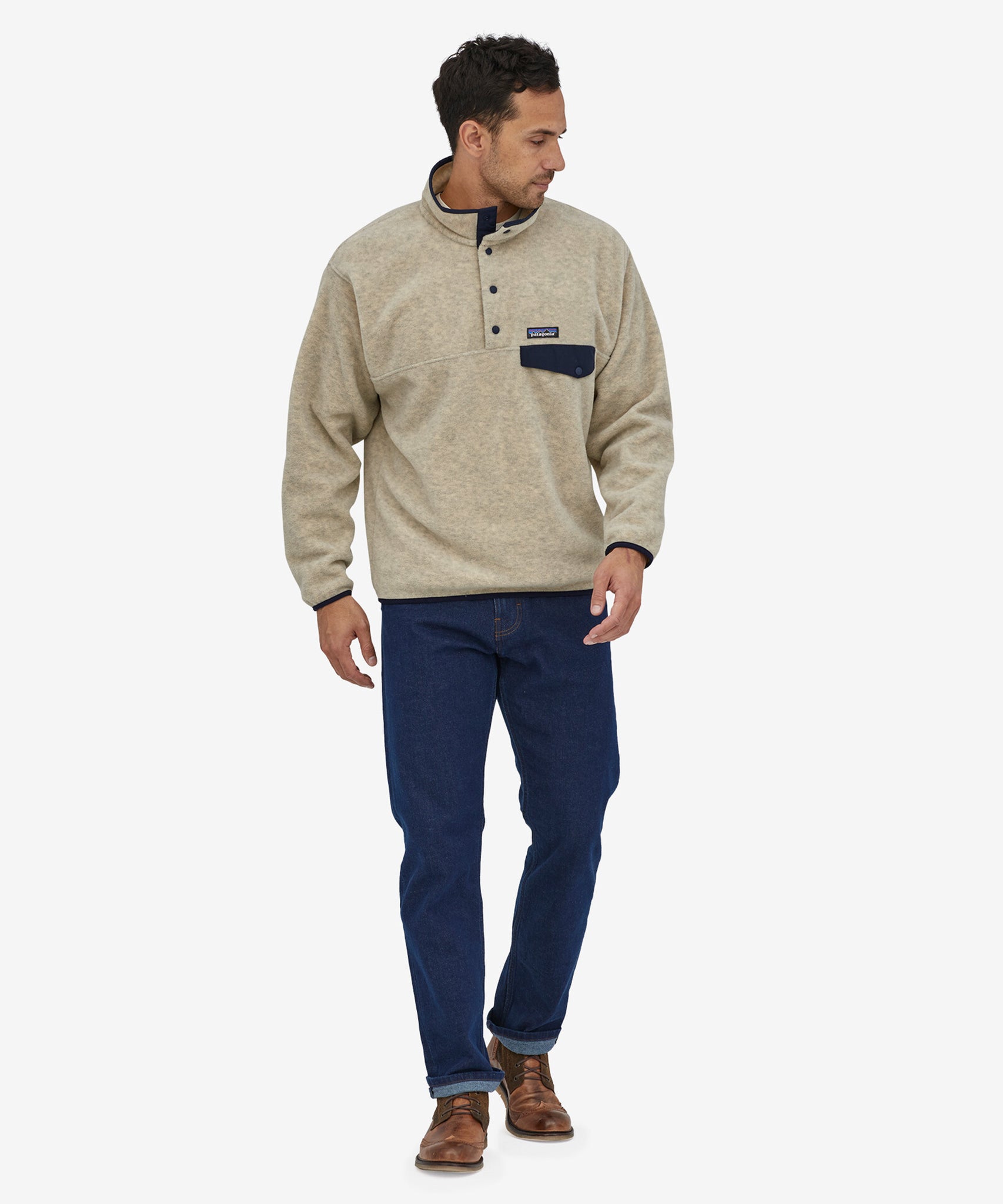 An adult wearing the Patagonia Men's Synchilla Snap-T Fleece - Oatmeal Heather, and blue jeans