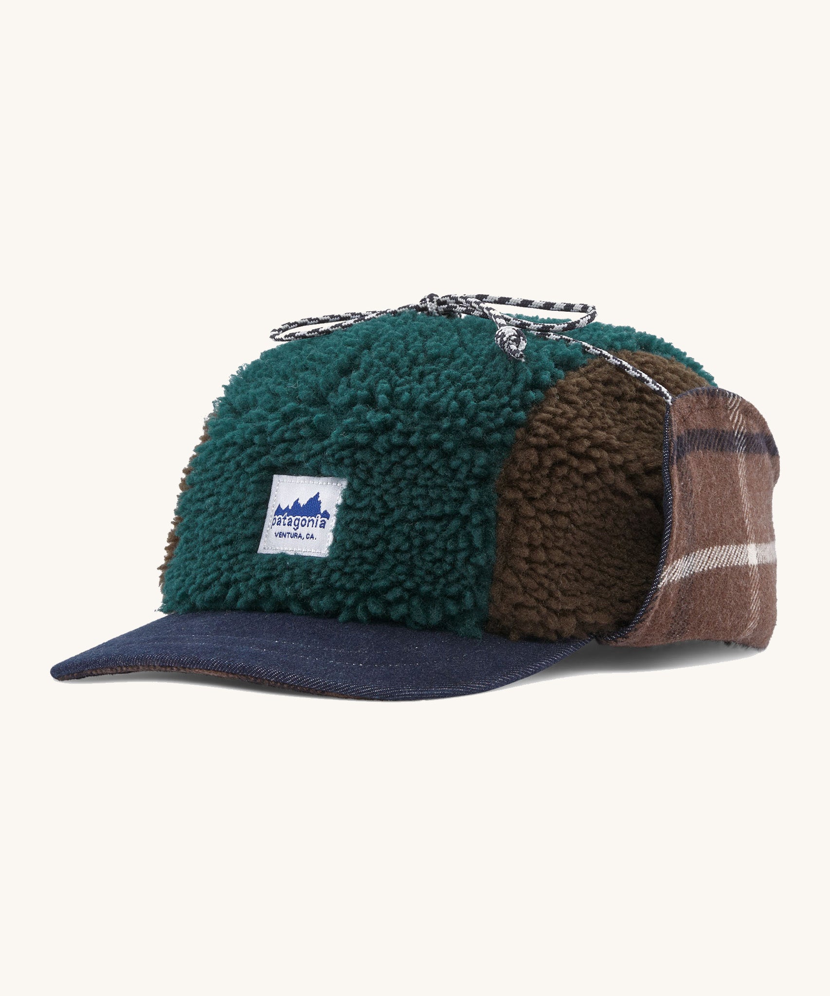 Patagonia adult range cap in cascade green available at Babipur. Showing the a check style front panel and features earflaps to keep the ears warm and a tie to keep them up. 