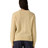The back of a woman wearing the Patagonia Women's cream Recycled Wool-Blend Crewneck Sweater in chevron cable available at Babipur.