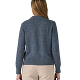 The back of a woman wearing the Patagonia Women's Recycled Wool-Blend Crewneck Sweater in dark blue with dappled design available at Babipur.