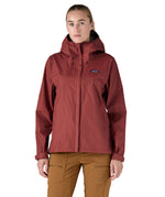 A person wearing the Patagonia Women's Torrentshell 3L Rain Jacket - Oxide Red, to show the fit of the jacket from the front