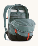 Patagonia refugio 26L back pack in sage blue with the main compartment open and a laptop in the sleeve at the back.