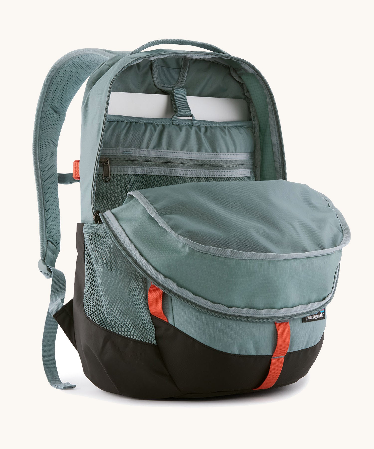 Patagonia refugio 26L back pack in sage blue with the main compartment open and a laptop in the sleeve at the back.
