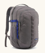 Patagonia 30L refugio backpack in grey. Features a side bottle holder and blue and grey gear loops and quick release buckles.