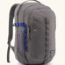 Patagonia 30L refugio backpack in grey. Features a side bottle holder and blue and grey gear loops and quick release buckles.