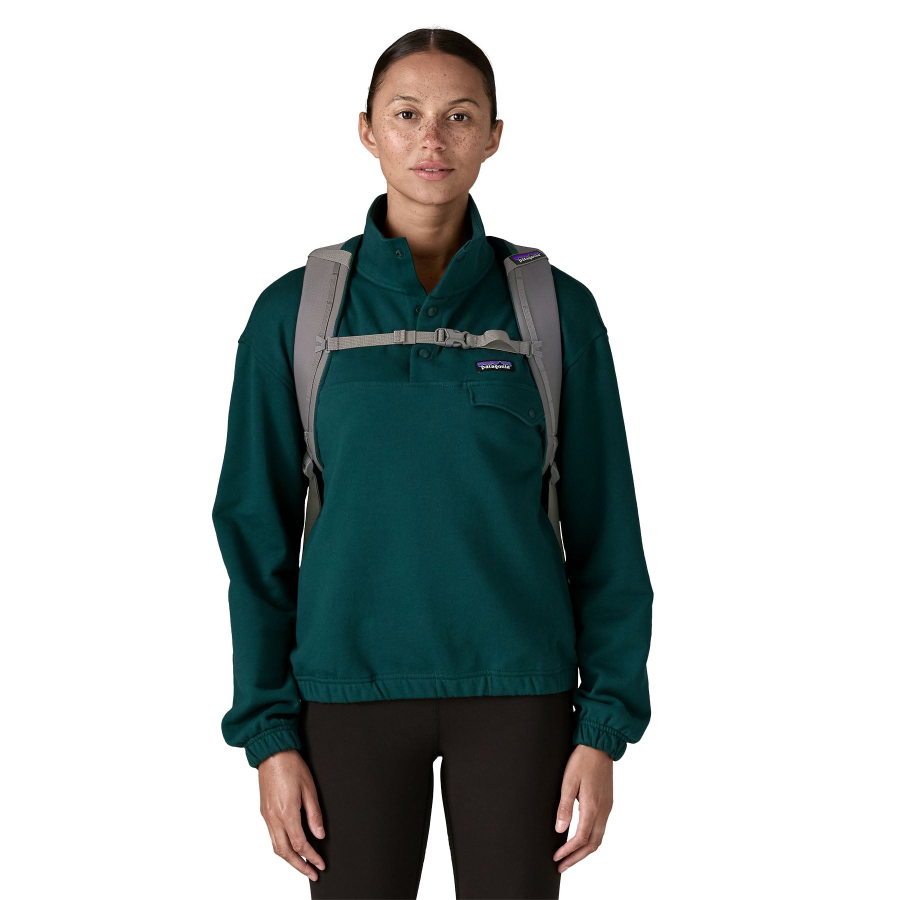 A woman wearing the Patagonia refugito day pack 26 litres in noble grey available at Babipur showing the chest strap detail
