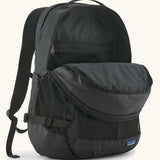 Patagonia 30L refugio backpack in black with opened zipped compartments.