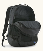 Patagonia 30L refugio backpack in black with opened zipped compartments.