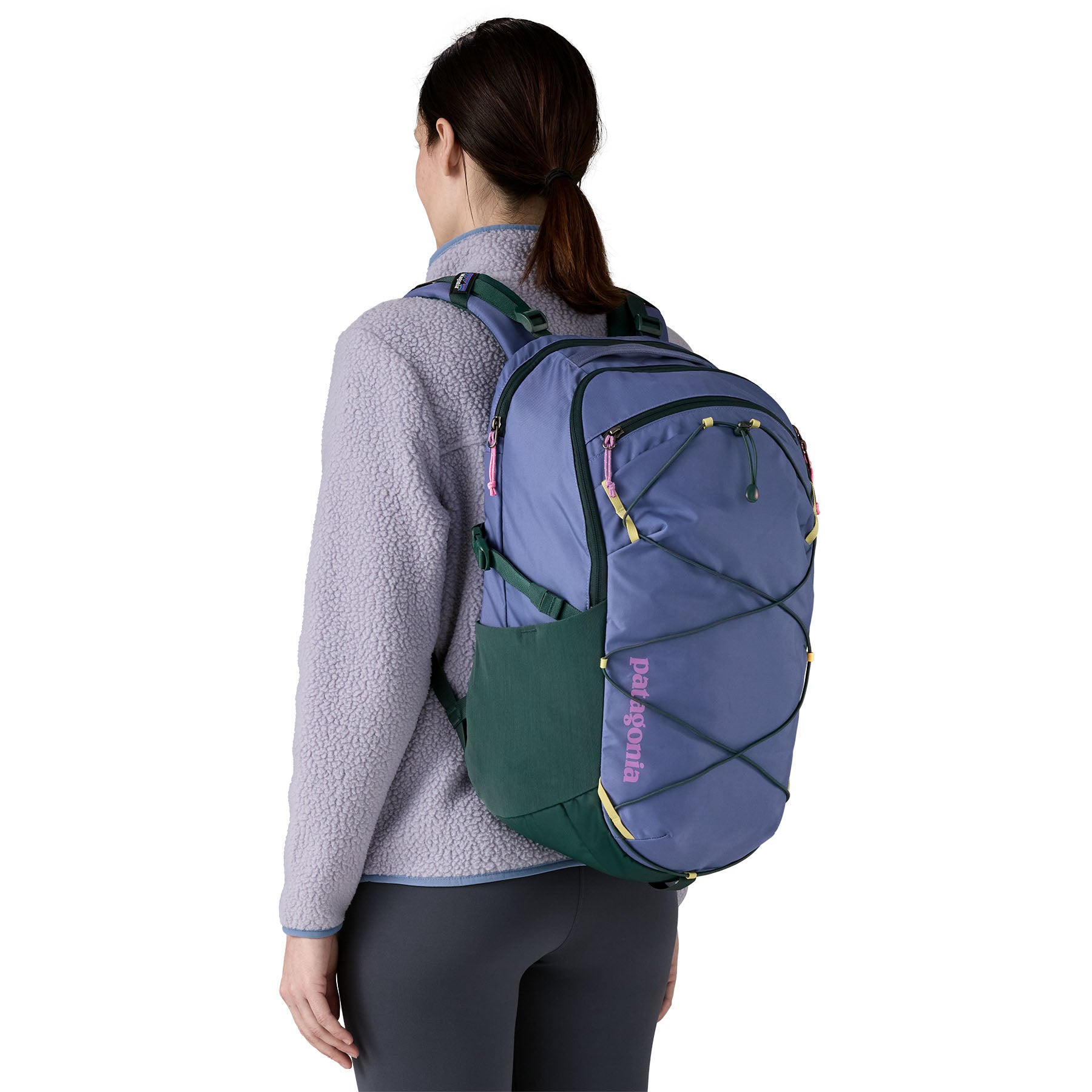 The back of a man wearing the Patagonia refugio 30 litres day pack in current blue available at Babipur showing the mesh side pocket and bungee cord detail on the front panel