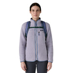 A woman wearing the Patagonia refugio 30 litres day pack in current blue available at Babipur showing the chest strap detail. 