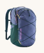Patagonia refugio 30 litres day pack in current blue. A 100% recycled material backpack in dark blue with dark green, yellow and pink detail. Features padded shoulder pads, mesh side pockets and a bungee cord on the front to keep items secured