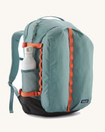 Patagonia refugio 32L daypack in sage blue and orange trim. Shows a water bottle mesh side pockets 