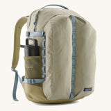 Patagonia refugio 32L daypack in light green and blue trim. Shows a water bottle mesh side pockets 