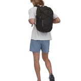 A person wearing the Patagonia Refugio Day Pack 30L Black, showing the back pack from the front