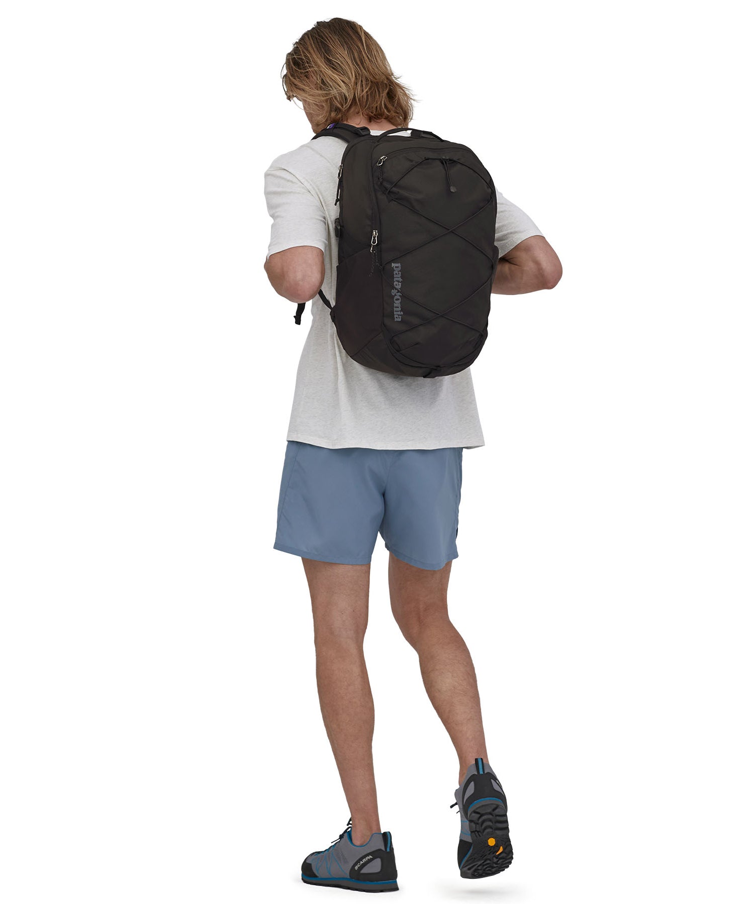 A person wearing the Patagonia Refugio Day Pack 30L Black, showing the back pack from the front