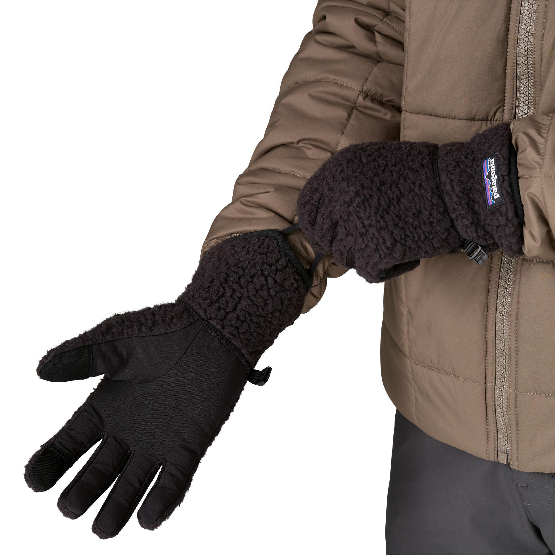 An adult putting on the Patagonia retro pile fleece gloves in black available at Babipur.