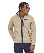 A man wearing the Patagonia retro pile fleece in natural colour showing the fit of the jacket and the zip detail.                                     