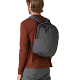 A reverse image of a man wearing the Patagonia smolder  blue 24L atom day pack available at Babipur.