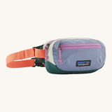 Patagonia terravia mini bum bag in patchwork/barnacle blue available at Babipur. A 100%  recycled material pack in blue and dark green with pink detail. Features 2 main zipped compartments and a buckle fastener on a orange strap