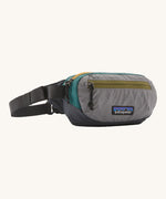 Patagonia terravia mini bum bag in noble grey available at Babipur. A 100%  recycled material pack in grey and dark green with yellow and green detail. Features 2 main zipped compartments and a buckle fastener