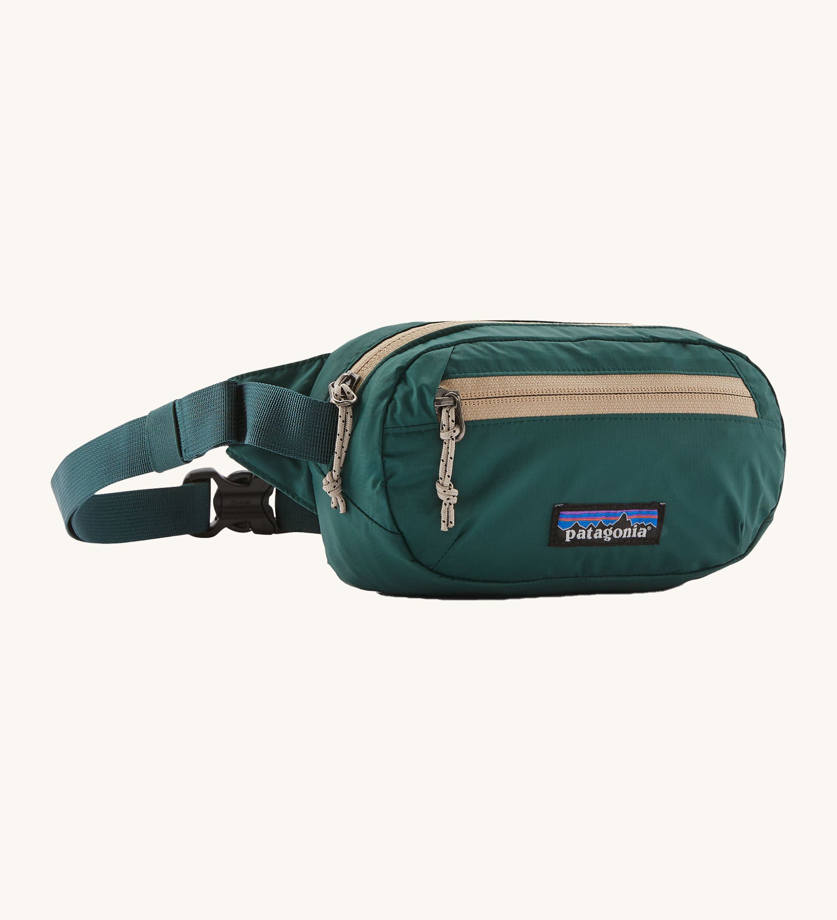 Patagonia terravia mini bum bag in cascade green available at Babipur. A 100%  recycled material pack dark green with cream detail. Features 2 main zipped compartments and a buckle fastener