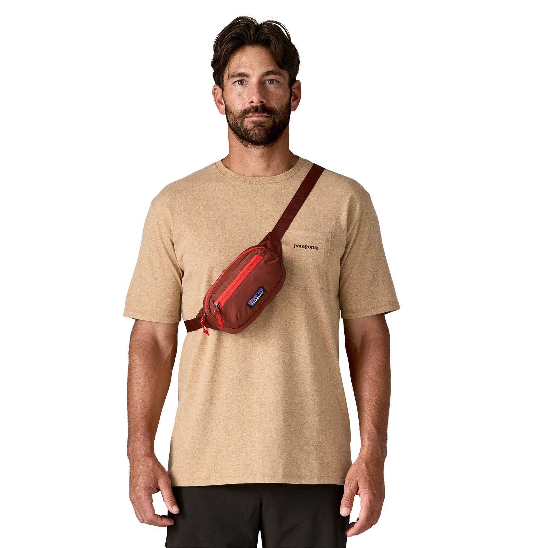 A man wearing the Patagonia terravia mini bum bag in dried vanilla over the shoulder available at Babipur