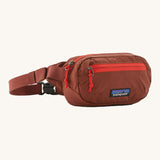 Patagonia terravia mini bum bag in dried vanilla available at Babipur. A 100%  recycled material pack in dark red with bright red detail. Features 2 main zipped compartments and a buckle fastener 