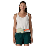 A woman wearing the Patagonia terravia mini bum bag in lichen green available at Babipur around the waist showing the zipped compartment on the front panel