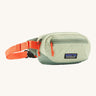 Patagonia terravia mini bum bag in lichen green available at Babipur. A 100%  recycled material pack in pastel green with bright orange detail. Features 2 main zipped compartments and a buckle fastener on a orange strap