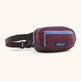 Patagonia 100% recycled nylon weather resistant terravia mini hip pack in maroon. Features 2 compartments with lilac zip detail